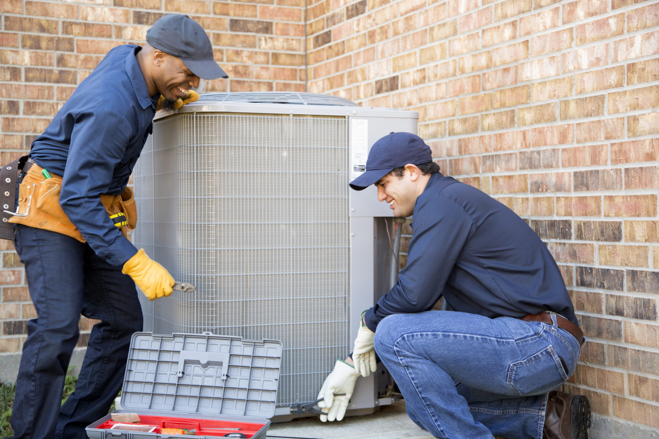 HVAC technicians installing air conditioner